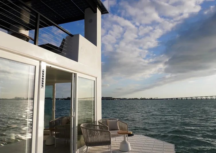  Yacht Photos Pics Floating home Arkup 50 on water, modern design, outdoor seating, ocean view, cloudy sky.