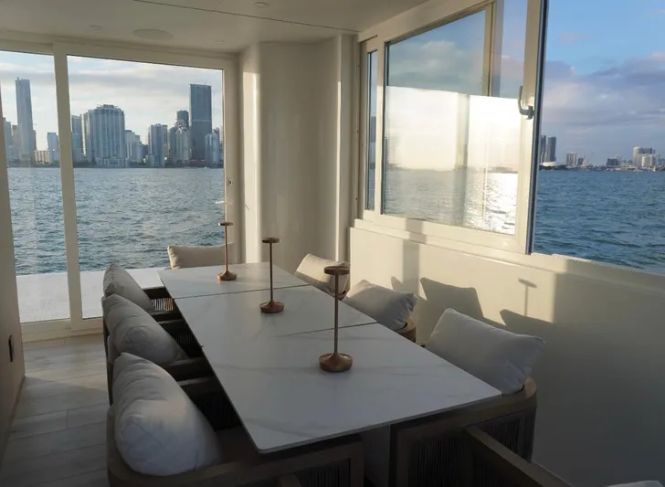  Yacht Photos Pics Modern dining area on Arkup 50 houseboat with city skyline view, 2025 model.
