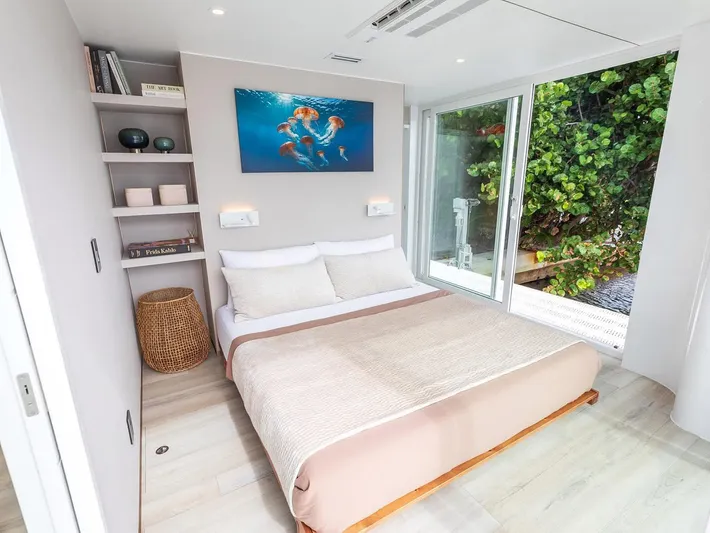  Yacht Photos Pics Modern bedroom in Arkup 50 houseboat, featuring a cozy bed and large window with greenery view.