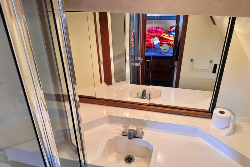  Yacht Photos Pics Bathroom interior of 1989 Bayliner 4588 Pilothouse with sink, mirror, and shower.