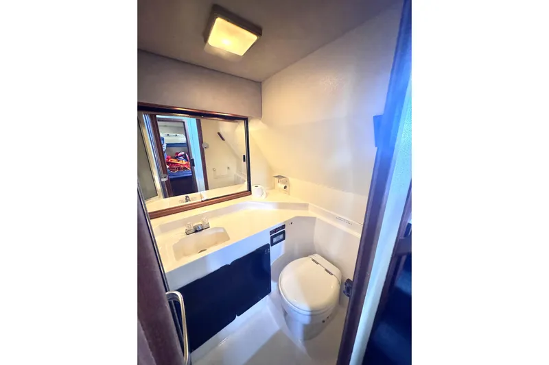  Yacht Photos Pics 1989 Bayliner 4588 Pilothouse bathroom with sink, toilet, and mirror.