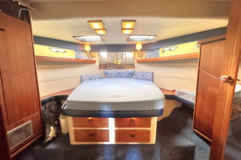  Yacht Photos Pics 1989 Bayliner 4588 Pilothouse interior cabin with bed, wood accents, and soft lighting.