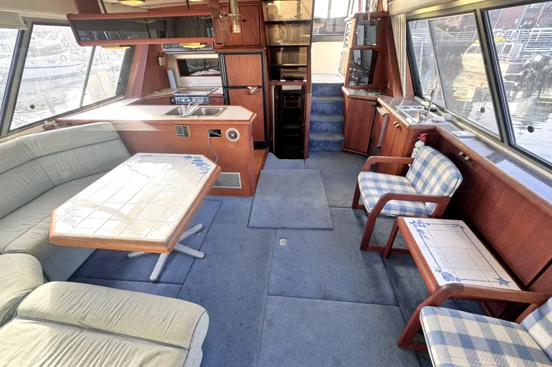  Yacht Photos Pics Interior of 1989 Bayliner 4588 Pilothouse with seating, table, and kitchenette.