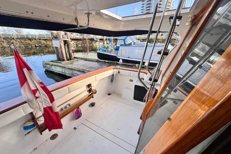  Yacht Photos Pics 1989 Bayliner 4588 Pilothouse yacht deck with Canadian flag, docked at marina.