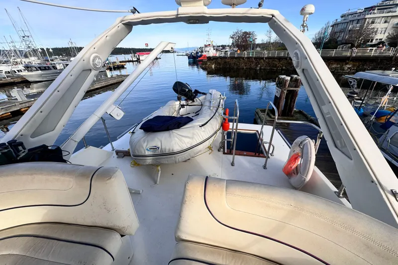  Yacht Photos Pics 1989 Bayliner 4588 Pilothouse yacht with inflatable boat on deck, docked at marina.