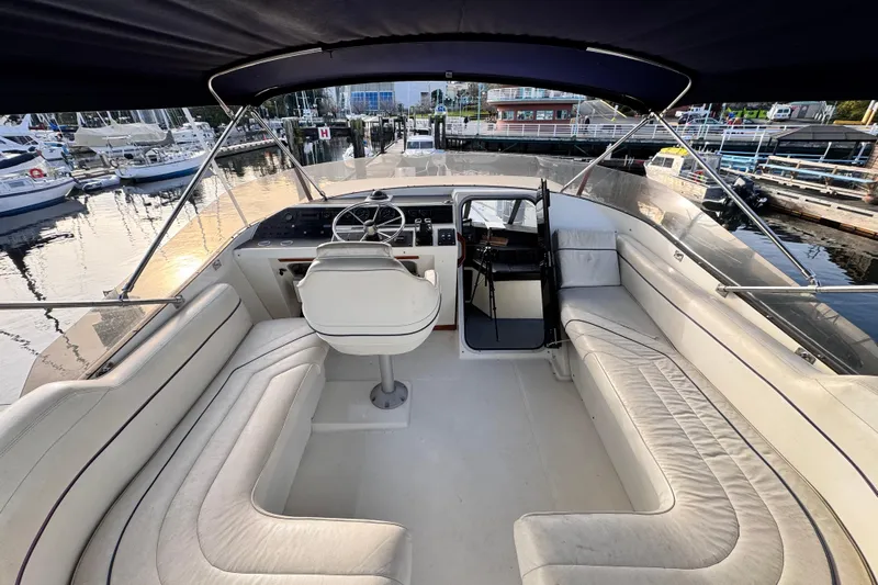  Yacht Photos Pics 1989 Bayliner 4588 Pilothouse yacht interior with seating and helm at marina.