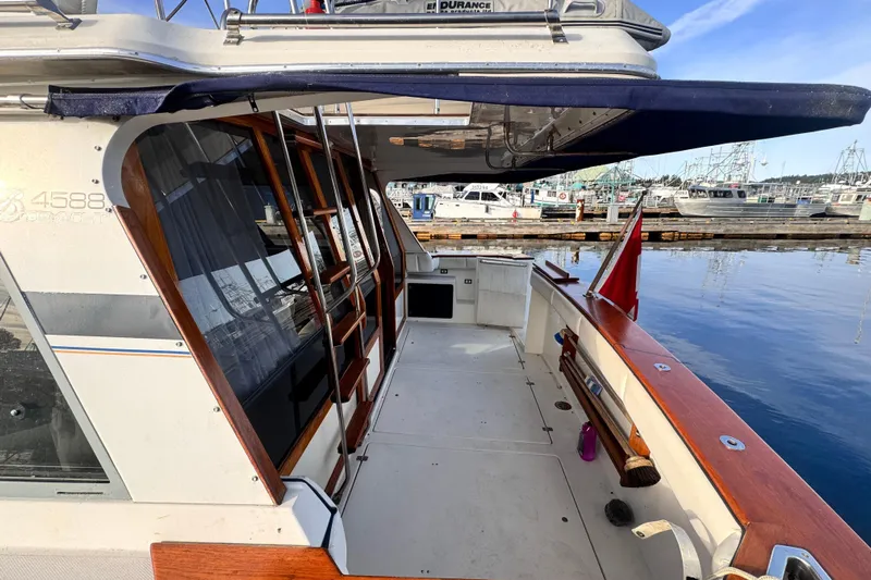  Yacht Photos Pics 1989 Bayliner 4588 Pilothouse yacht docked, showcasing spacious deck and elegant wood accents.