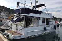 2016 Beneteau Swift Trawler 44 docked at marina, featuring blue canopy and white hull.