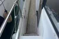 2016 Beneteau Swift Trawler 44, side deck view with railing and wooden flooring.