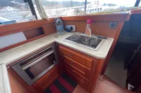 2016 Beneteau Swift Trawler 44 kitchen with stove, oven, and wooden cabinetry.