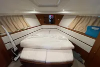 Cozy cabin interior of 2016 Beneteau Swift Trawler 44 with bed and curtains.