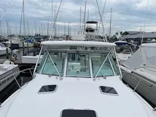 Pathological Yacht Photos Pics Pursuit 3400 Express 2000 in harbor, surrounded by sailboats.