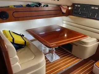 Pathological Yacht Photos Pics Interior of 2000 Pursuit 3400 Express with wooden table and leather seating.