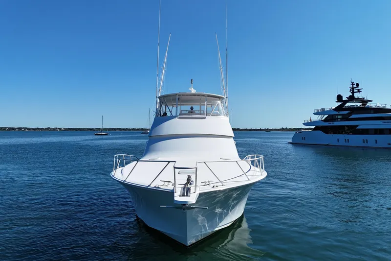 On The Ball Yacht Photos Pics 2006 Viking 56 Convertible yacht on calm water, clear blue sky background.