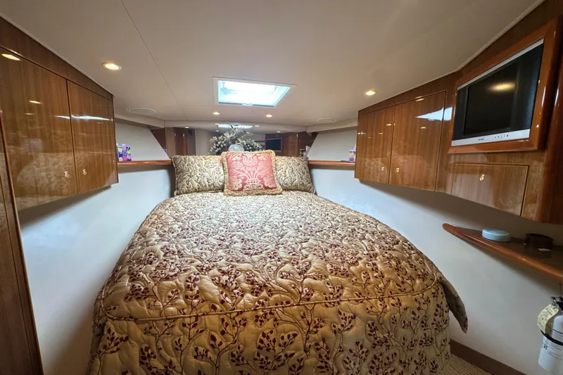 On The Ball Yacht Photos Pics Luxurious bedroom interior of 2006 Viking 56 Convertible yacht with elegant bedding and wood cabinetry.