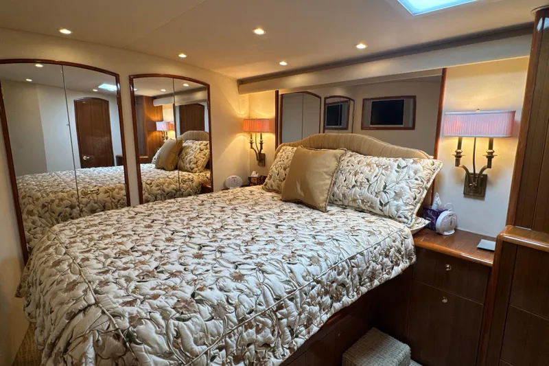 On The Ball Yacht Photos Pics Luxurious bedroom interior of 2006 Viking 56 Convertible yacht with elegant bedding and warm lighting.