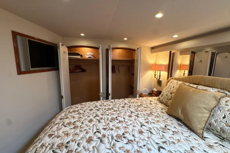On The Ball Yacht Photos Pics Luxurious bedroom interior of 2006 Viking 56 Convertible yacht with closet and TV.