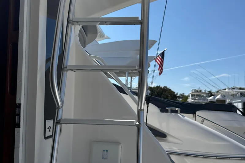 On The Ball Yacht Photos Pics Ladder on 2006 Viking 56 Convertible yacht with American flag in background.