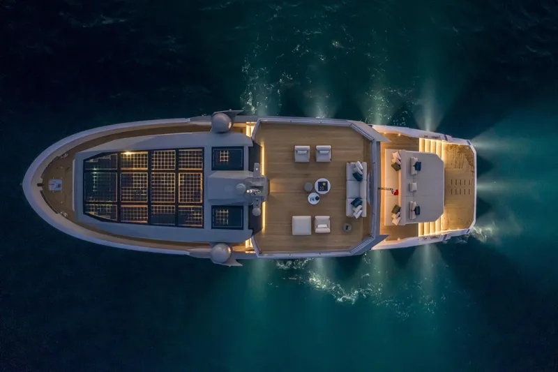 Mabelle Yacht Photos Pics Aerial view of 2022 Arcadia Yachts Sherpa 80 XL, illuminated on the water at night.