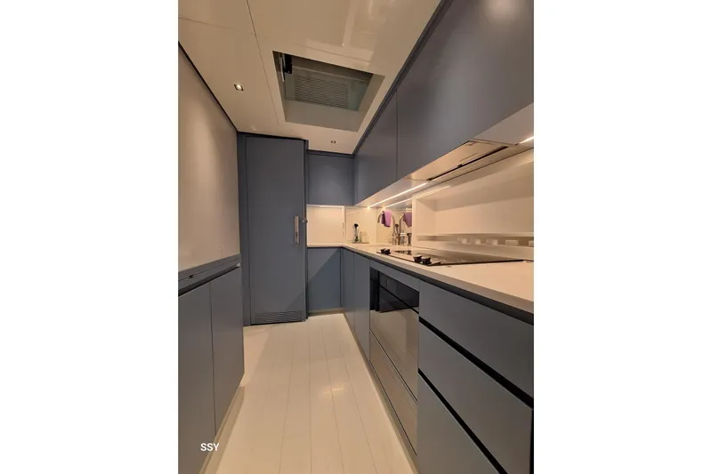 Mabelle Yacht Photos Pics Modern kitchen interior on 2022 Arcadia Yachts Sherpa 80 XL, featuring sleek cabinetry and appliances.