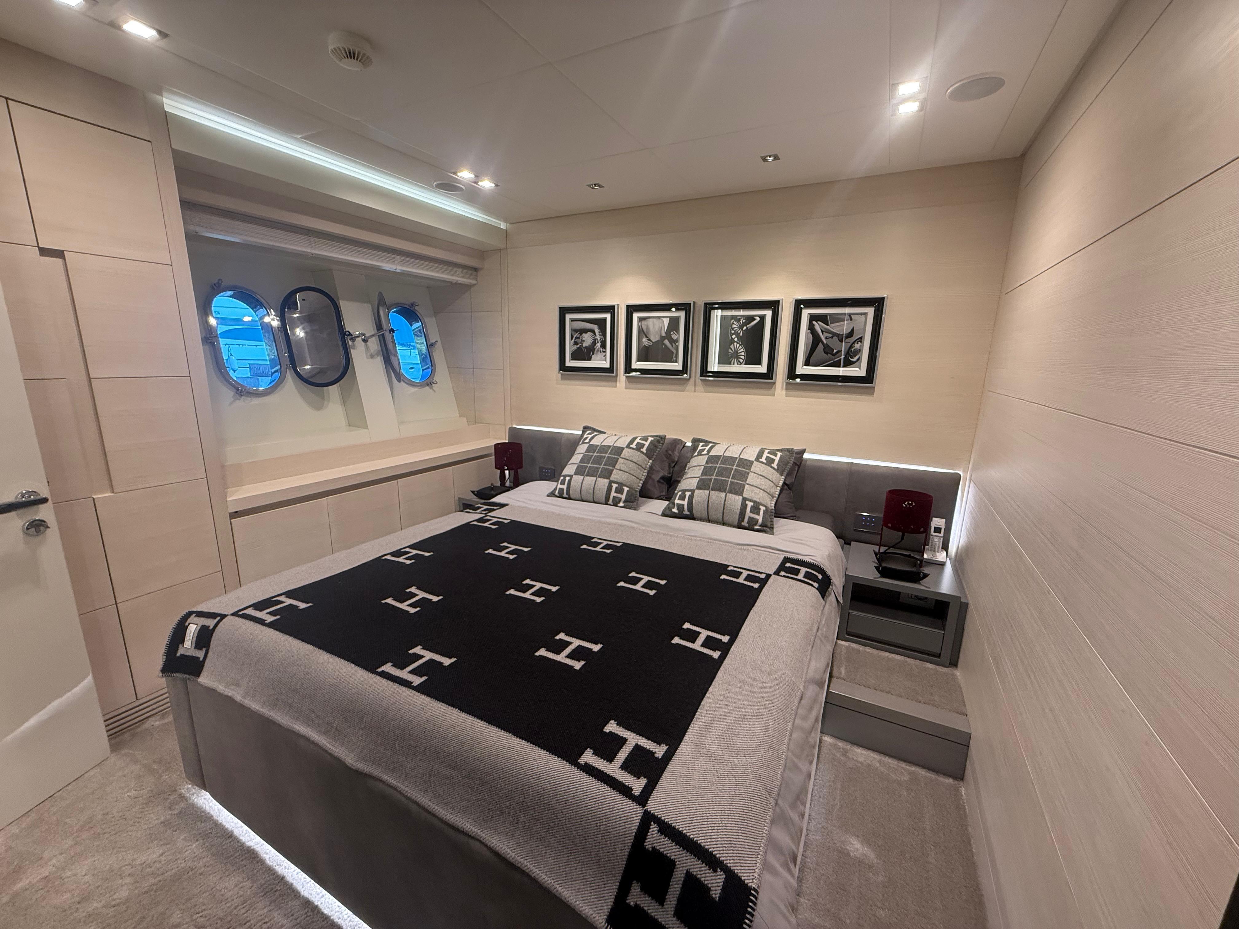Luxurious yacht bedroom with modern decor, featuring porthole windows and stylish bedding, AB 100, 2017.