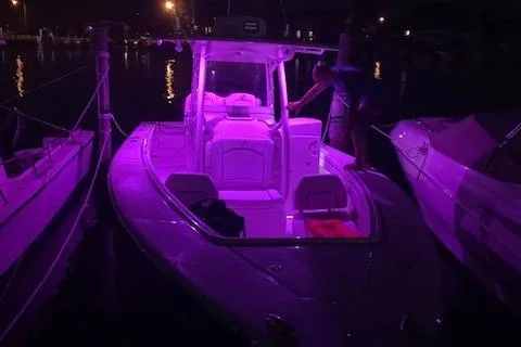  Yacht Photos Pics 2018 Jupiter 29 HFS boat illuminated with purple lights at night, docked in a marina.