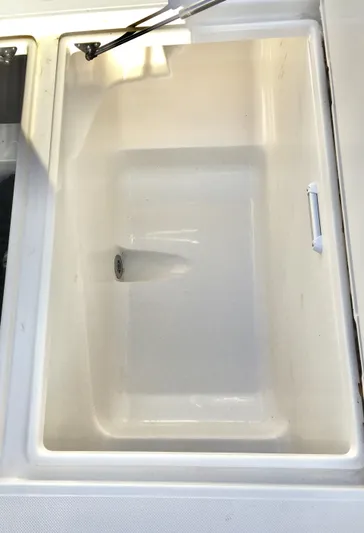  Yacht Photos Pics 2018 Jupiter 29 HFS boat compartment, white interior, open lid, drain visible.