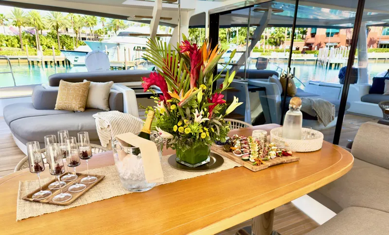 Twin Flame Yacht Photos Pics Luxurious Lagoon Seventy 7 yacht interior with elegant dining setup and vibrant floral centerpiece.