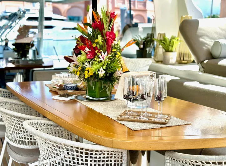 Twin Flame Yacht Photos Pics Luxurious Lagoon Seventy 7 yacht interior with elegant dining setup and vibrant floral centerpiece.