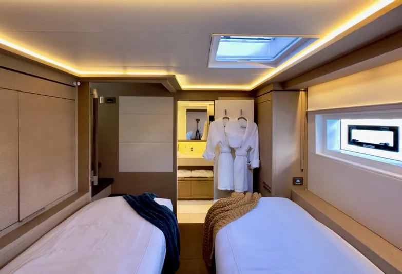 Twin Flame Yacht Photos Pics Luxurious cabin interior of 2020 Lagoon Seventy 7 yacht with twin beds and robes.