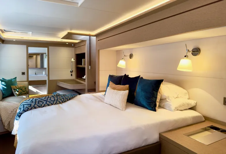 Twin Flame Yacht Photos Pics Luxurious bedroom interior of 2020 Lagoon Seventy 7 yacht with modern decor and ambient lighting.