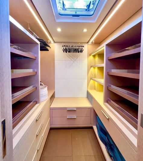 Twin Flame Yacht Photos Pics Luxurious walk-in closet on 2020 Lagoon Seventy 7 yacht with ample shelving and lighting.