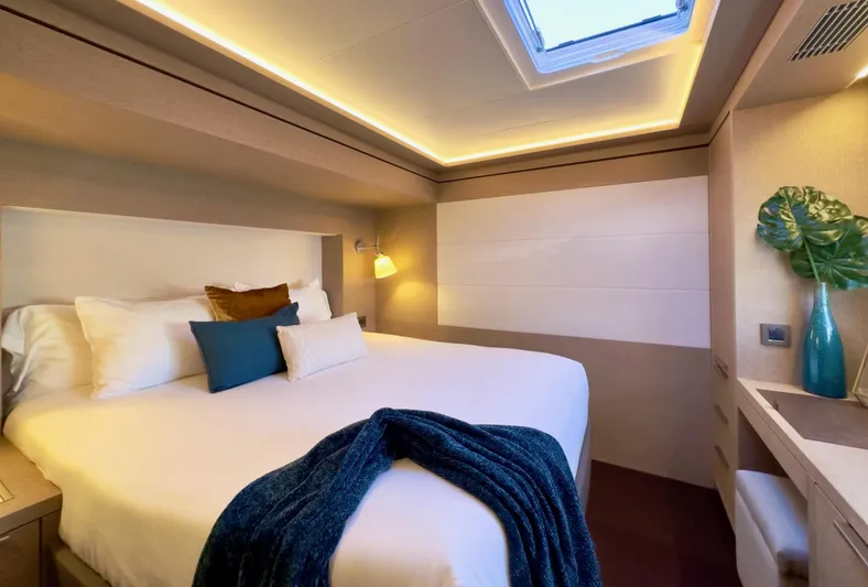 Twin Flame Yacht Photos Pics Luxurious bedroom interior of 2020 Lagoon Seventy 7 yacht with modern decor and skylight.