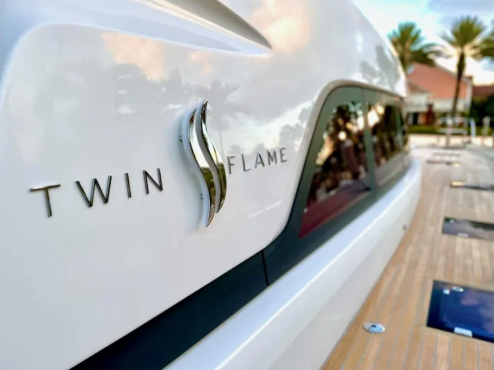 Twin Flame Yacht Photos Pics 2020 Lagoon Seventy 7 yacht with "Twin Flame" emblem, docked with palm trees in background.