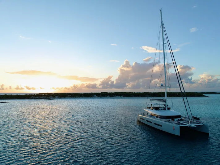 Twin Flame Yacht Photos Pics Luxurious 2020 Lagoon Seventy 7 yacht sailing at sunset on tranquil waters.