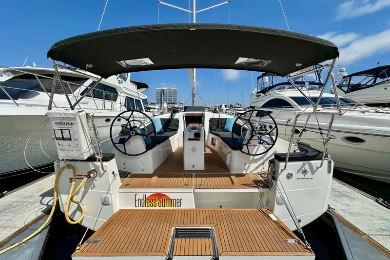 Endless Summer Yacht Photos Pics 2024 Jeanneau Sun Odyssey 410 sailboat with dual steering wheels, docked at a marina.