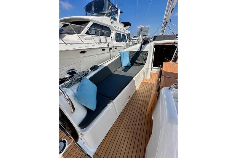 Endless Summer Yacht Photos Pics 2024 Jeanneau Sun Odyssey 410 yacht deck with cushioned seating and wooden flooring.