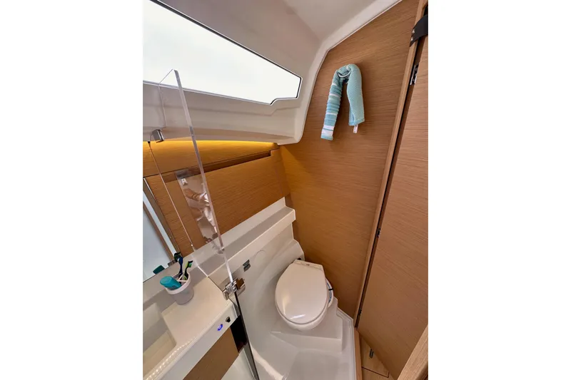 Endless Summer Yacht Photos Pics 2024 Jeanneau Sun Odyssey 410 bathroom with modern fixtures and wooden accents.