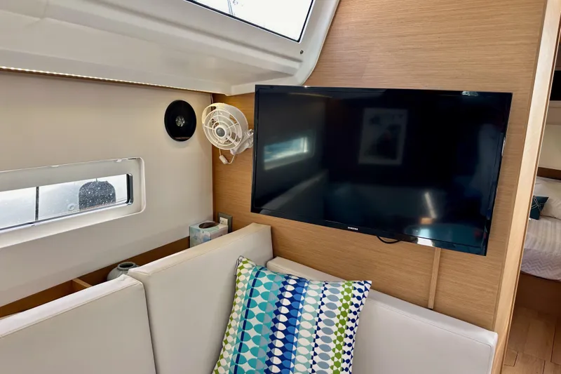Endless Summer Yacht Photos Pics 2024 Jeanneau Sun Odyssey 410 interior with TV, fan, and colorful cushion.