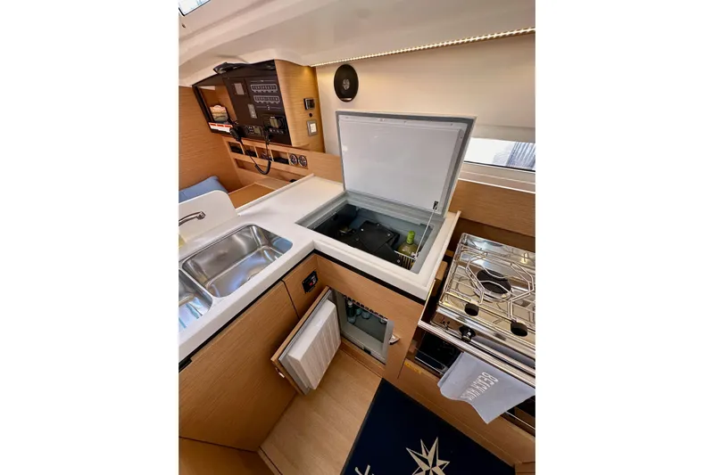 Endless Summer Yacht Photos Pics Modern kitchen interior of 2024 Jeanneau Sun Odyssey 410 yacht, featuring sink, stove, and storage.