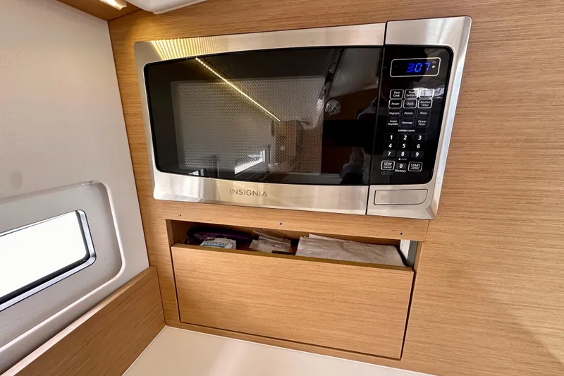 Endless Summer Yacht Photos Pics Microwave in 2024 Jeanneau Sun Odyssey 410 yacht kitchen, featuring modern wood cabinetry.