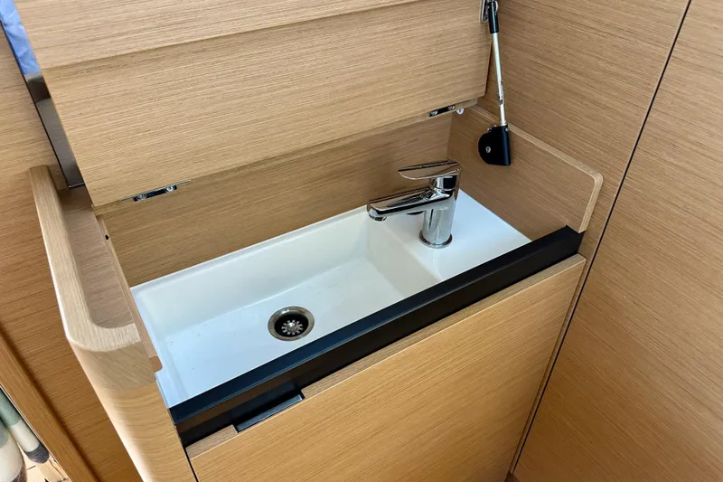 Endless Summer Yacht Photos Pics 2024 Jeanneau Sun Odyssey 410 interior sink with modern faucet and wooden cabinetry.