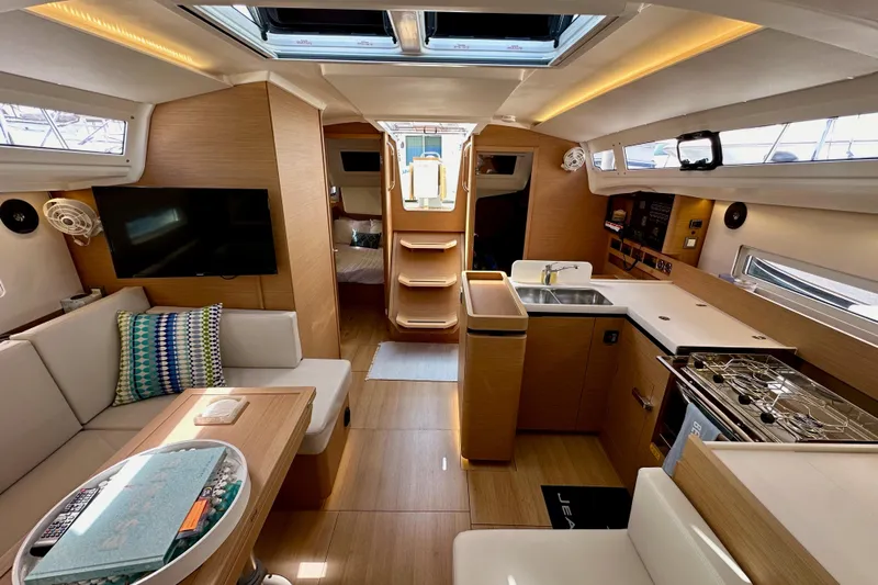 Endless Summer Yacht Photos Pics Luxurious interior of 2024 Jeanneau Sun Odyssey 410 sailboat, featuring modern kitchen and seating area.