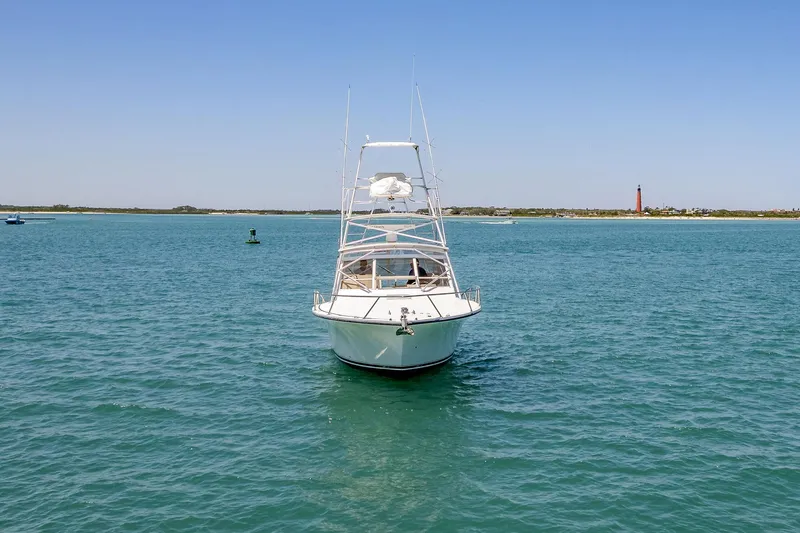Patriot Yacht Photos Pics 2005 Carolina Classic 32 boat on open water with distant shoreline and lighthouse.