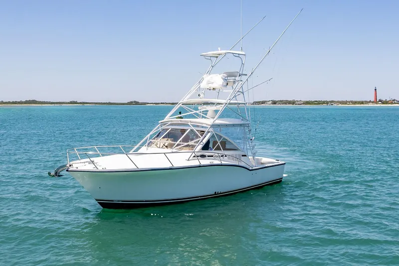 Patriot Yacht Photos Pics 2005 Carolina Classic 32 boat on clear blue water with distant shoreline.