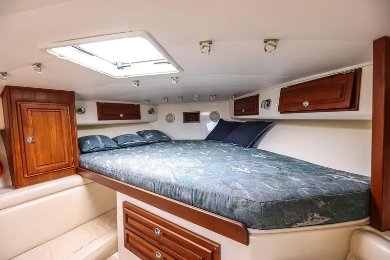 Patriot Yacht Photos Pics 2005 Carolina Classic 32 cabin interior with bed, wooden cabinets, and overhead lighting.
