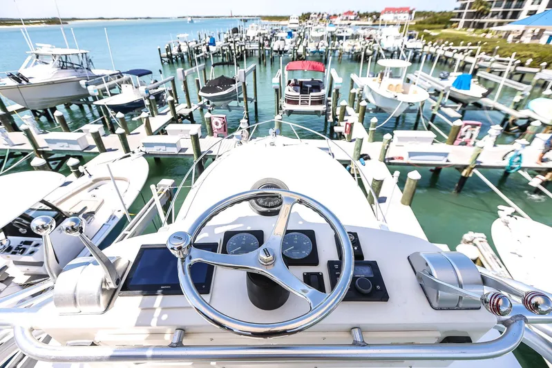 Patriot Yacht Photos Pics Helm view of a 2005 Carolina Classic 32 at a marina with multiple boats docked.