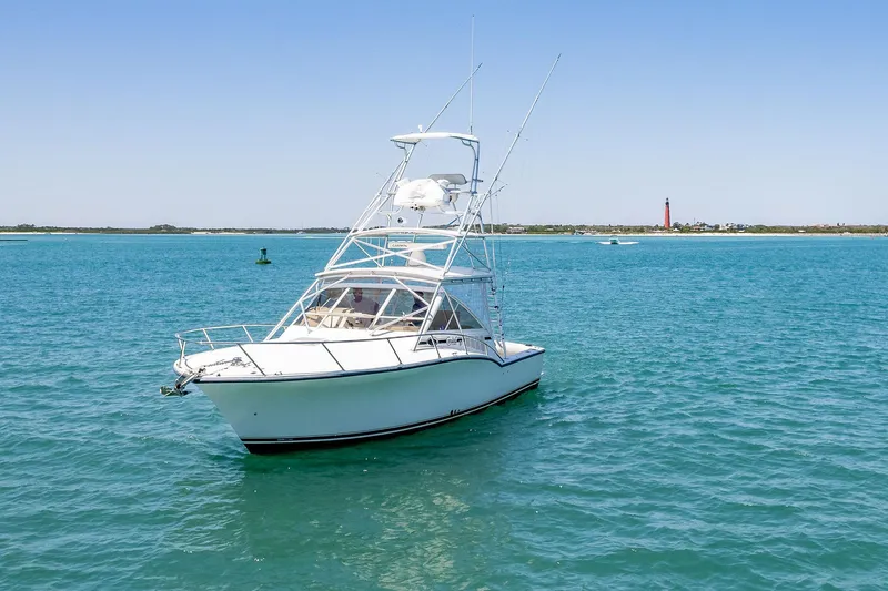 Patriot Yacht Photos Pics 2005 Carolina Classic 32 boat on clear blue water with distant shoreline.