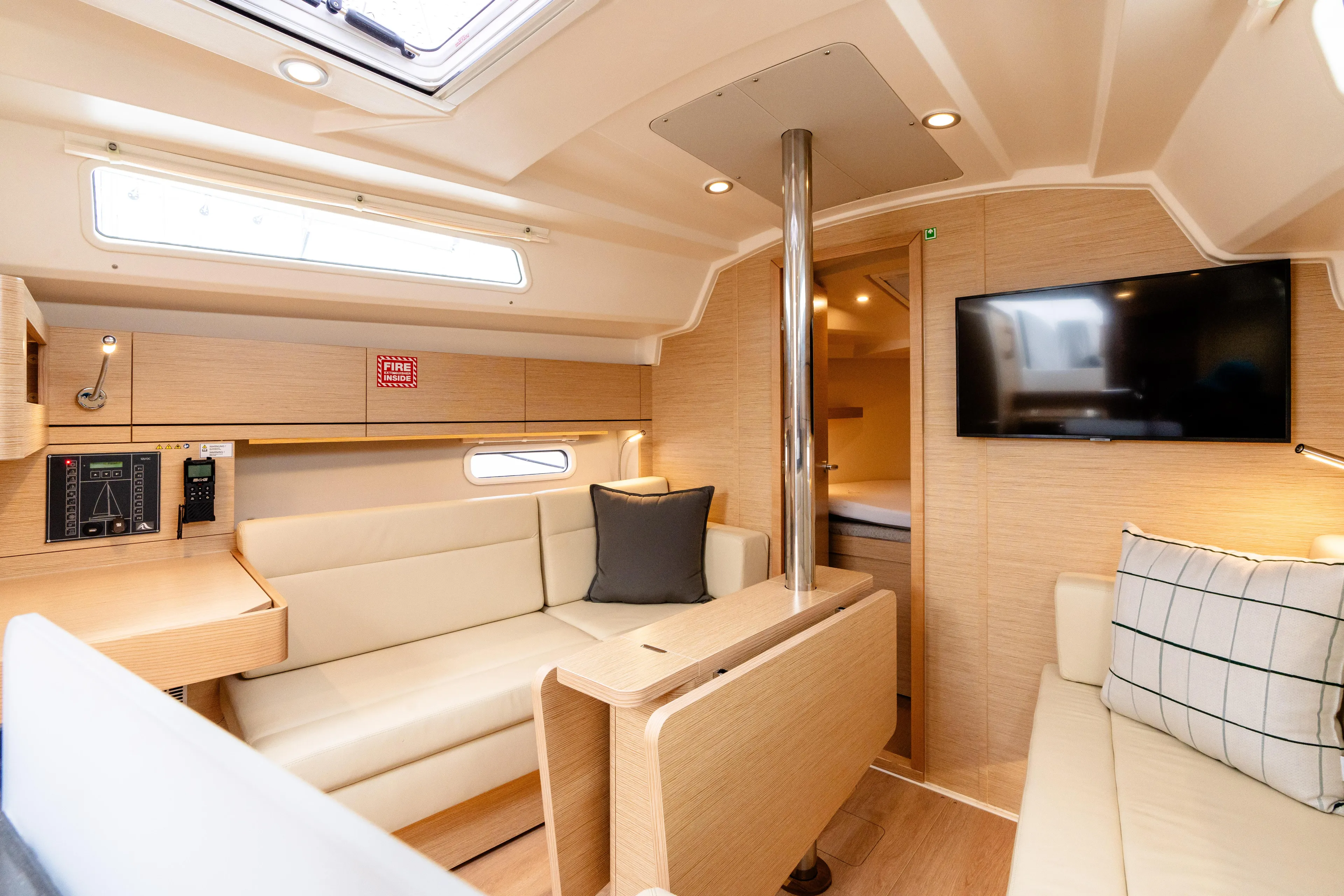 The Siren's Song Yacht Photos Pics Luxurious interior of 2023 Hanse 348 yacht with modern seating and TV.