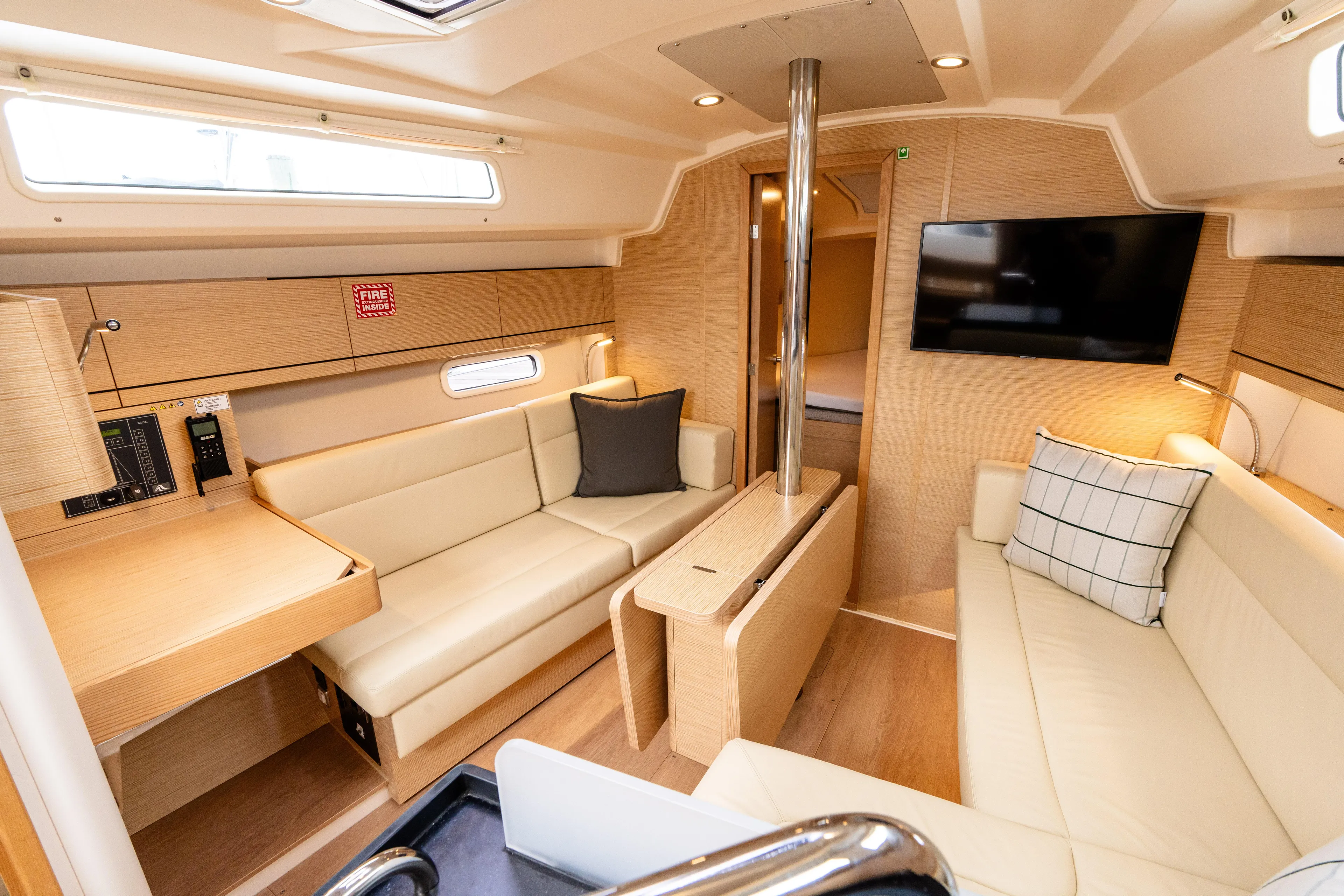 The Siren's Song Yacht Photos Pics Luxurious interior of 2023 Hanse 348 yacht with modern seating and entertainment system.